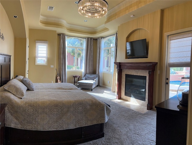 bedroom featuring access to exterior, crown molding, carpet floors, a chandelier, and a tray ceiling