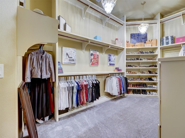 spacious closet featuring carpet and an inviting chandelier