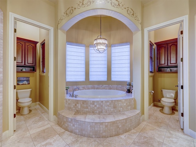 bathroom with a chandelier, tile patterned flooring, toilet, and tiled tub