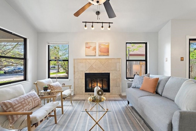 living room with hardwood / wood-style floors, ceiling fan, and a fireplace