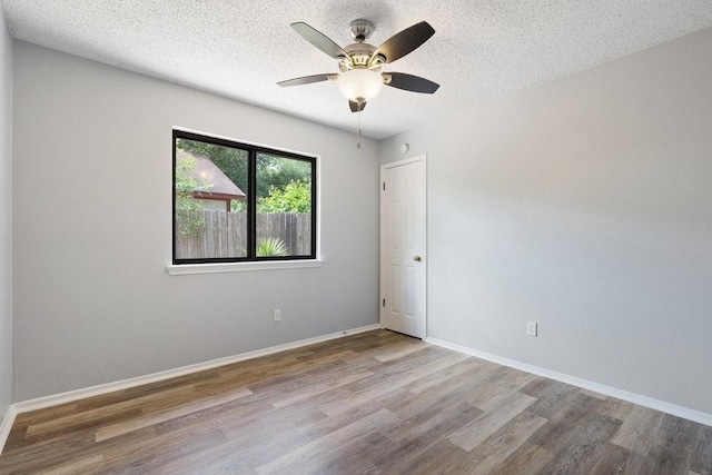 unfurnished room with hardwood / wood-style floors, ceiling fan, and a textured ceiling