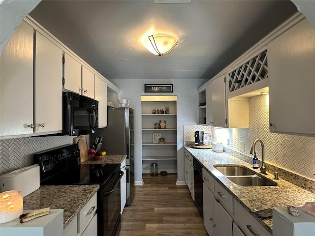 kitchen featuring decorative backsplash, light stone counters, sink, black appliances, and dark hardwood / wood-style floors