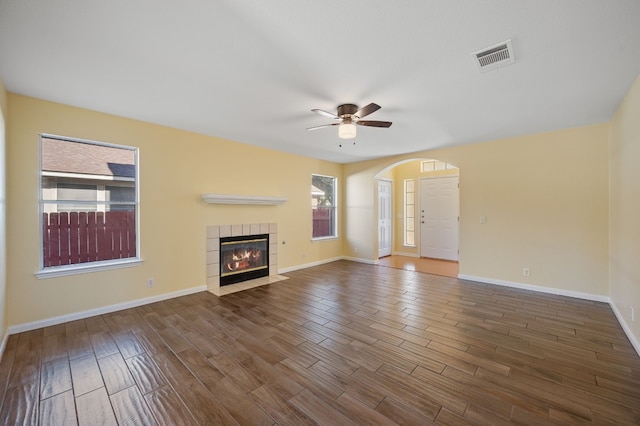 unfurnished living room with ceiling fan, a fireplace, and wood-type flooring