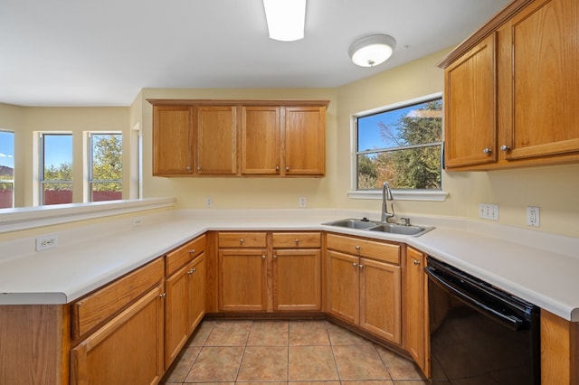 kitchen featuring a wealth of natural light, sink, light tile patterned floors, and black dishwasher