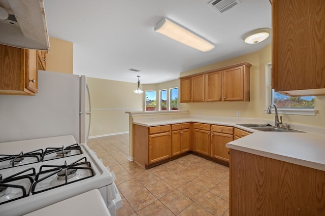 kitchen featuring sink, kitchen peninsula, decorative light fixtures, white appliances, and light tile patterned flooring