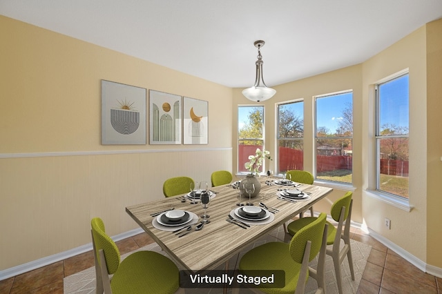 dining space with wood walls and tile patterned flooring