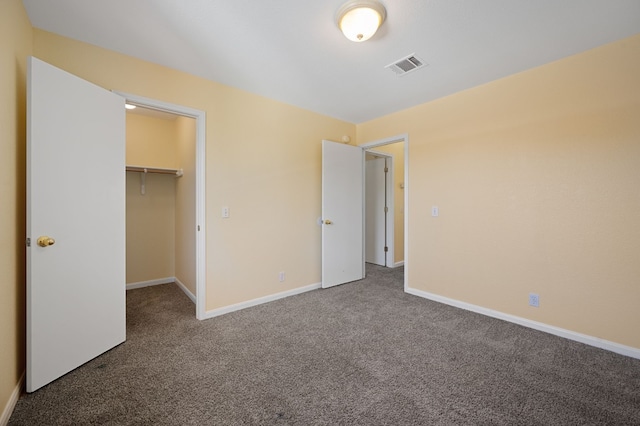 unfurnished bedroom featuring carpet floors, a spacious closet, and a closet