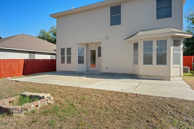 rear view of property with a yard, a patio, and cooling unit