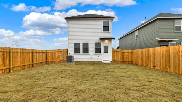 rear view of property featuring a yard and cooling unit