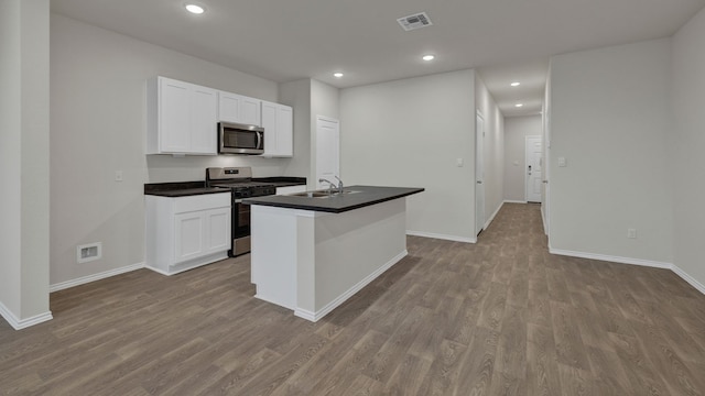 kitchen featuring stainless steel appliances, sink, a center island with sink, and white cabinets