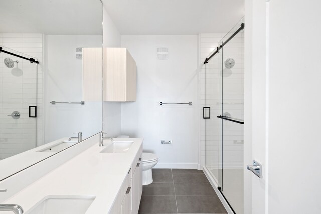 bathroom with tile patterned flooring, vanity, toilet, and walk in shower