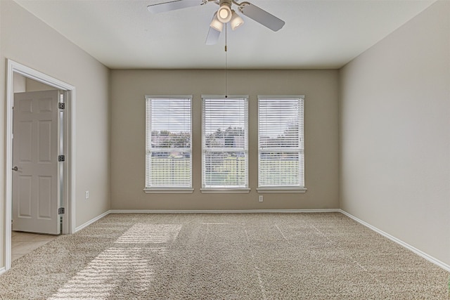 carpeted spare room featuring ceiling fan