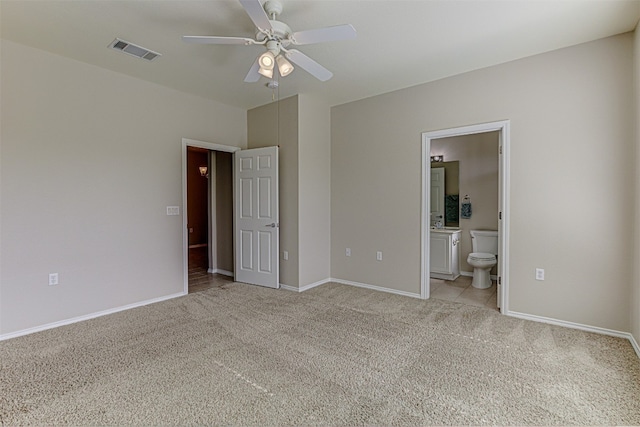 unfurnished bedroom featuring light carpet, ensuite bath, and ceiling fan