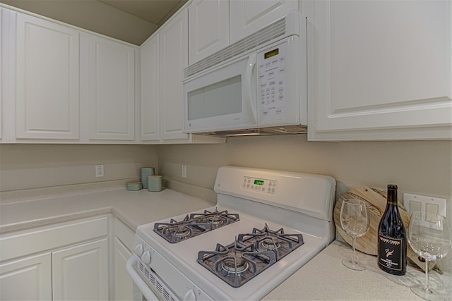 kitchen with white cabinetry and white appliances