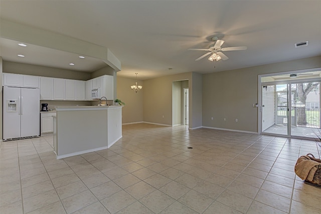 kitchen featuring white appliances, white cabinets, ceiling fan with notable chandelier, hanging light fixtures, and light tile patterned floors