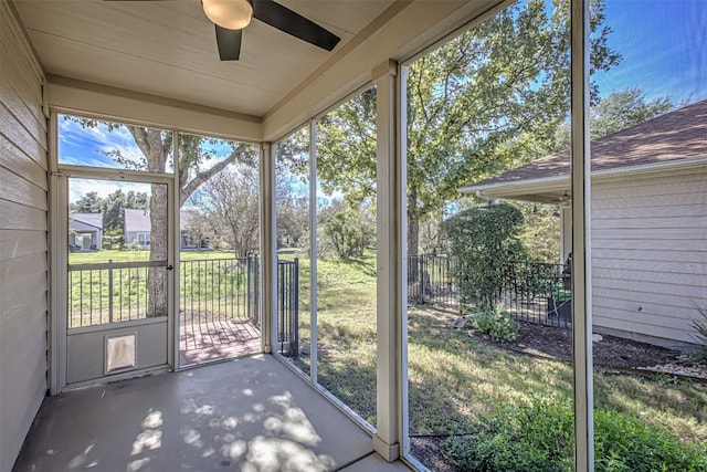 unfurnished sunroom featuring ceiling fan