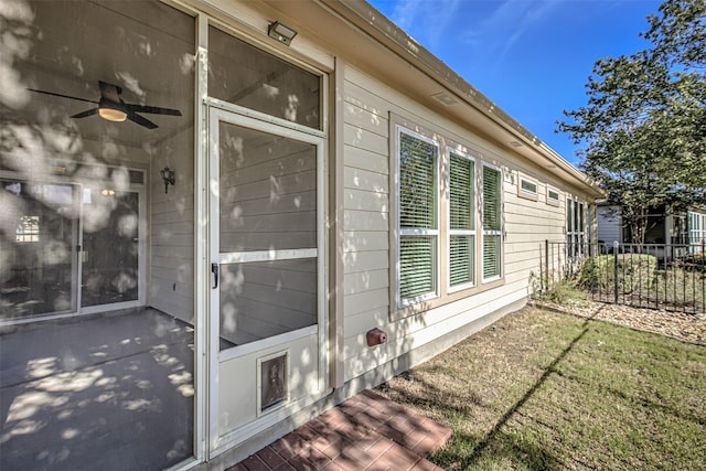 view of side of home featuring a yard and ceiling fan