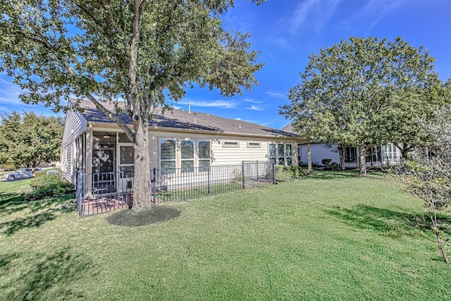 back of property featuring a sunroom and a yard