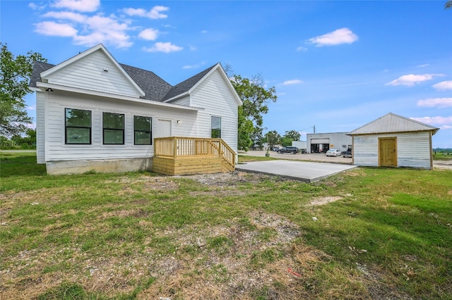 back of property with an outdoor structure and a lawn