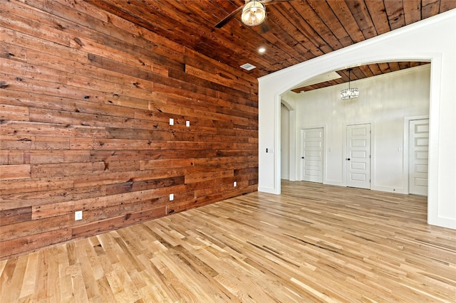 spare room with wood walls, ceiling fan, light hardwood / wood-style floors, and wooden ceiling