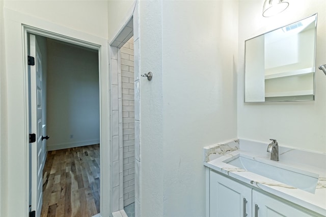 bathroom with vanity, hardwood / wood-style flooring, and walk in shower