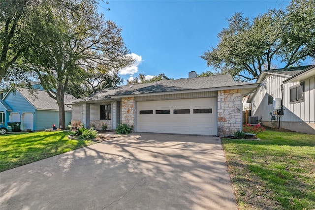 view of front of home featuring a front lawn, a garage, and central AC