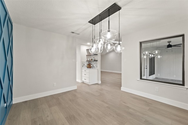 interior space featuring ceiling fan, light hardwood / wood-style floors, and a textured ceiling