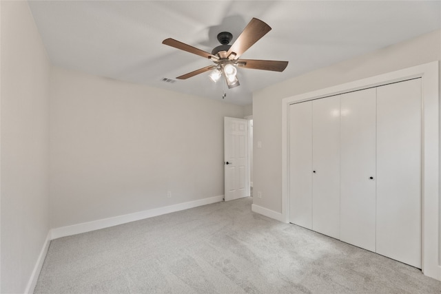 unfurnished bedroom with light carpet, a closet, and ceiling fan