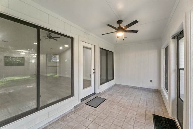 unfurnished sunroom with ceiling fan