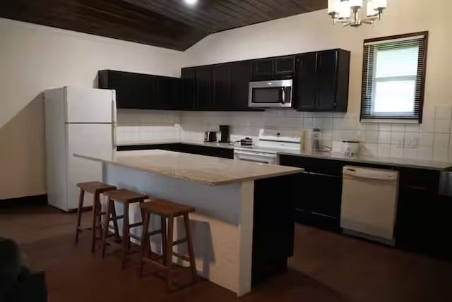 kitchen with a kitchen breakfast bar, backsplash, white appliances, wooden ceiling, and a center island