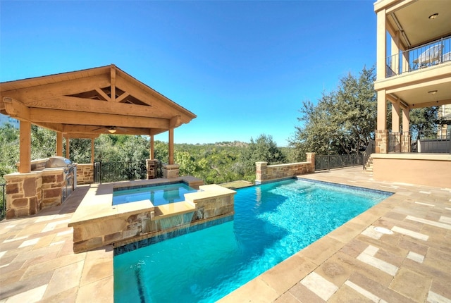 view of swimming pool featuring a grill, ceiling fan, a patio area, and exterior kitchen