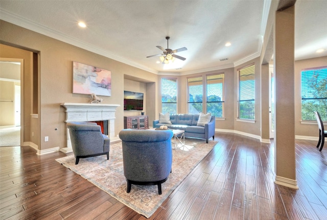 living room with ceiling fan, crown molding, and dark wood-type flooring