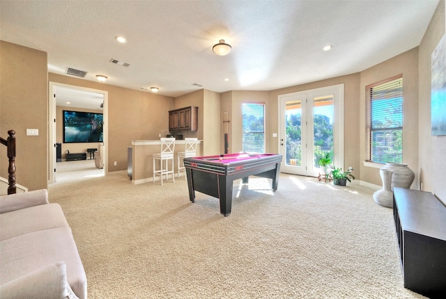 game room featuring light colored carpet, a textured ceiling, billiards, and indoor bar