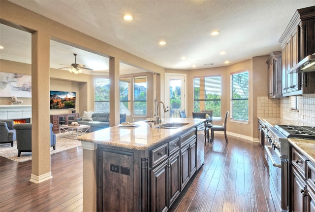 kitchen featuring dark hardwood / wood-style flooring, sink, stainless steel appliances, and a kitchen island with sink