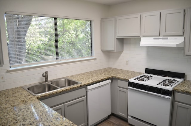 kitchen with white appliances, dark hardwood / wood-style floors, a healthy amount of sunlight, and sink