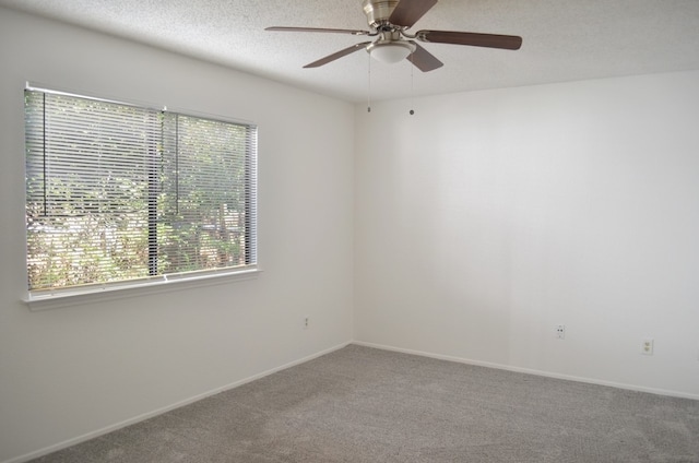 spare room with carpet, ceiling fan, and a textured ceiling