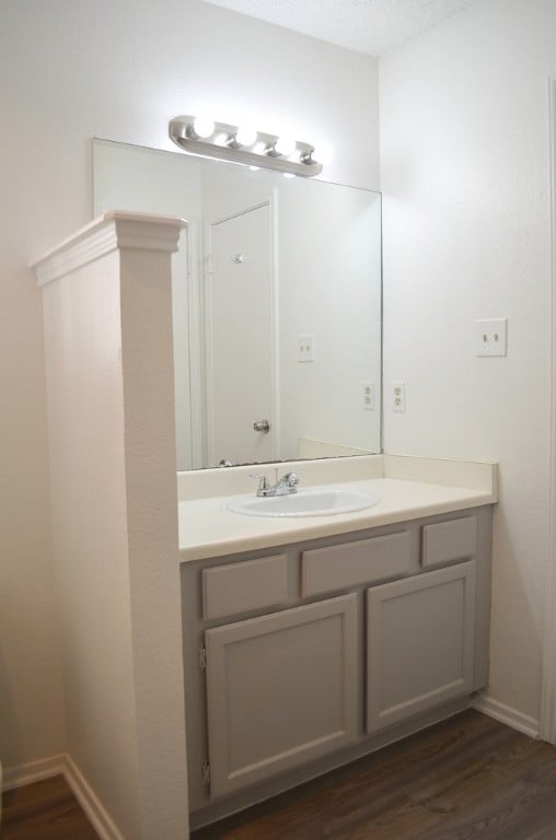 bathroom with hardwood / wood-style floors, vanity, and a textured ceiling