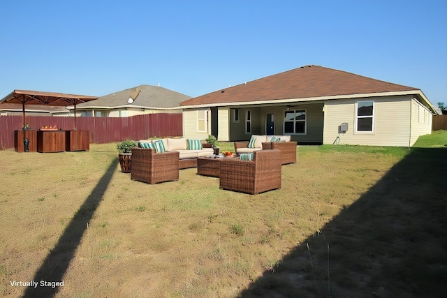 rear view of house featuring ceiling fan, a yard, a jacuzzi, and an outdoor hangout area