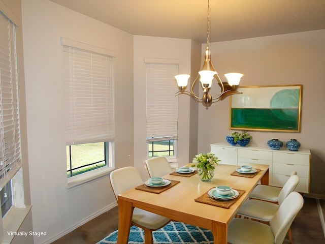 dining area featuring dark wood-type flooring and a chandelier