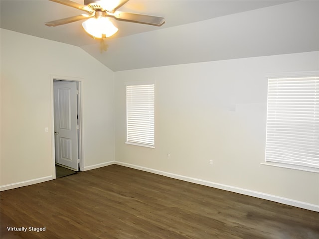 empty room featuring dark hardwood / wood-style floors, vaulted ceiling, and ceiling fan