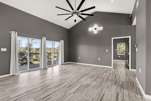 unfurnished living room with ceiling fan and vaulted ceiling