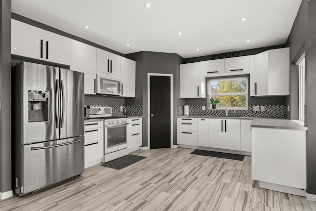 kitchen with white cabinetry, tasteful backsplash, stainless steel fridge with ice dispenser, and gas range