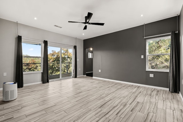 empty room with ceiling fan and light hardwood / wood-style flooring