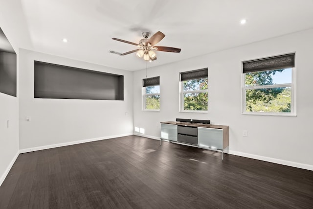 unfurnished living room featuring ceiling fan, dark hardwood / wood-style flooring, and a wealth of natural light