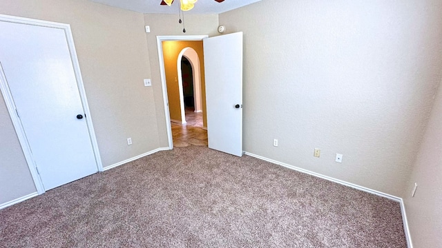 unfurnished bedroom with ceiling fan and carpet