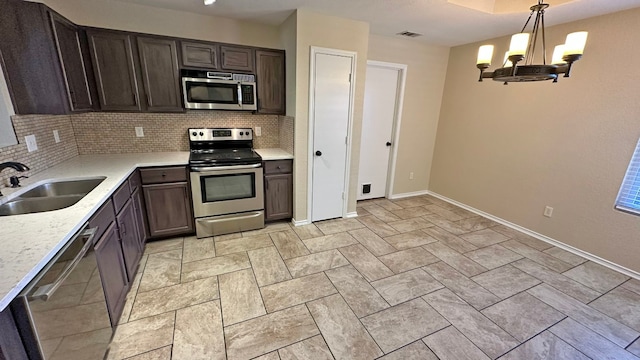 kitchen with sink, hanging light fixtures, tasteful backsplash, a notable chandelier, and stainless steel appliances