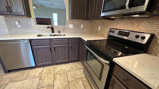 kitchen with decorative backsplash, sink, and stainless steel appliances