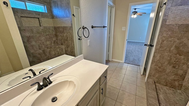 bathroom with tile patterned floors, vanity, ceiling fan, and tiled shower