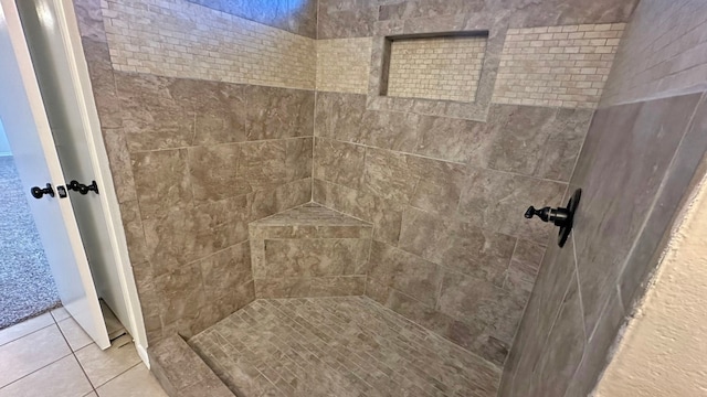 bathroom featuring tile patterned flooring and tiled shower