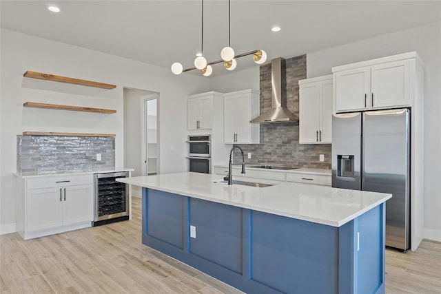 kitchen featuring white cabinetry, sink, beverage cooler, wall chimney range hood, and appliances with stainless steel finishes